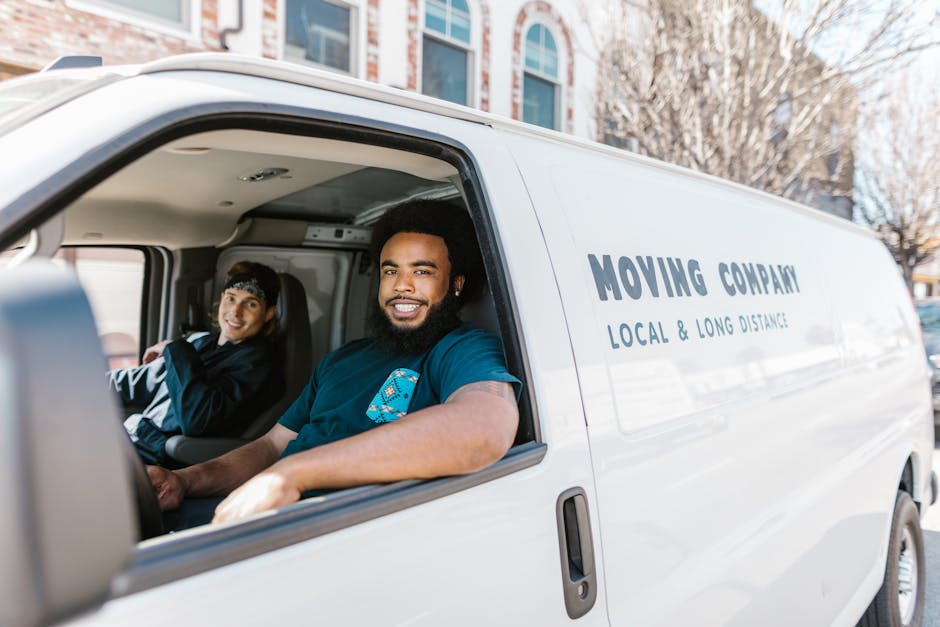 Friendly and professional movers smiling while handling boxes